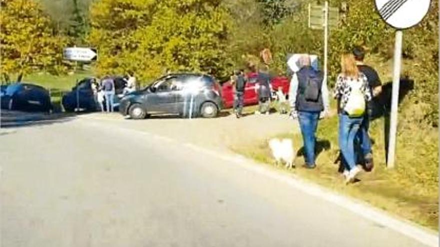 Turistes i cotxes en direcció a la Fageda d&#039;en Jordà, en un cap de setmana de tardor.