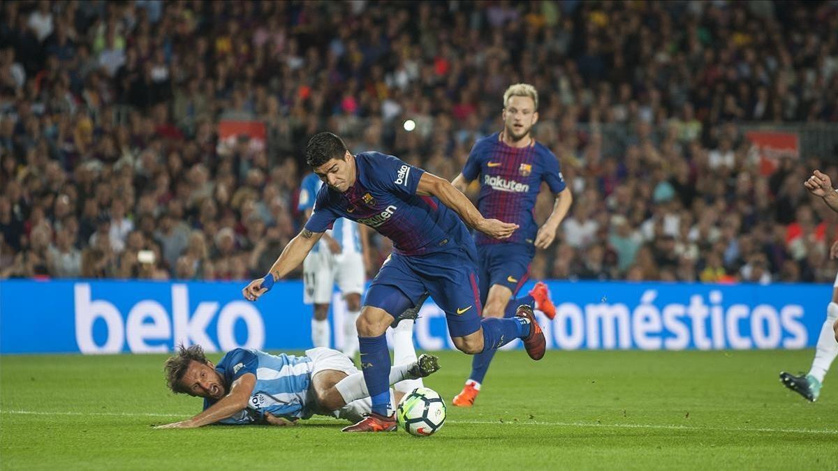 Luis Suárez se escapa de Baysse, el jugador del Málaga, en el Camp Nou.