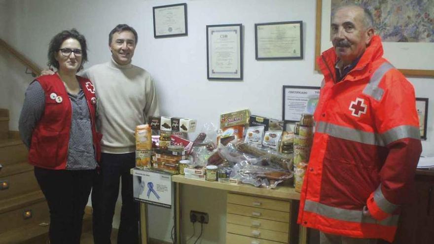 Amador Herrero (derecha), Paco Abollo y Sara Pérez, posan junto a la cesta de productos donada. Foto