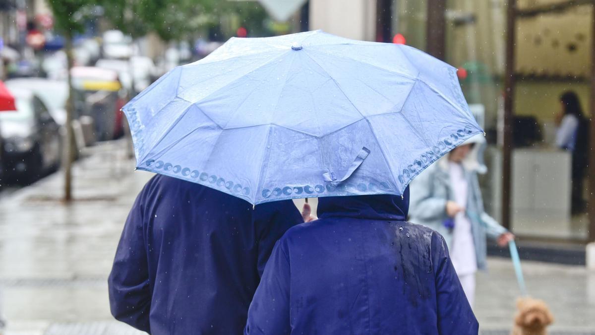 Gente paseando con paraguas este jueves en A Coruña