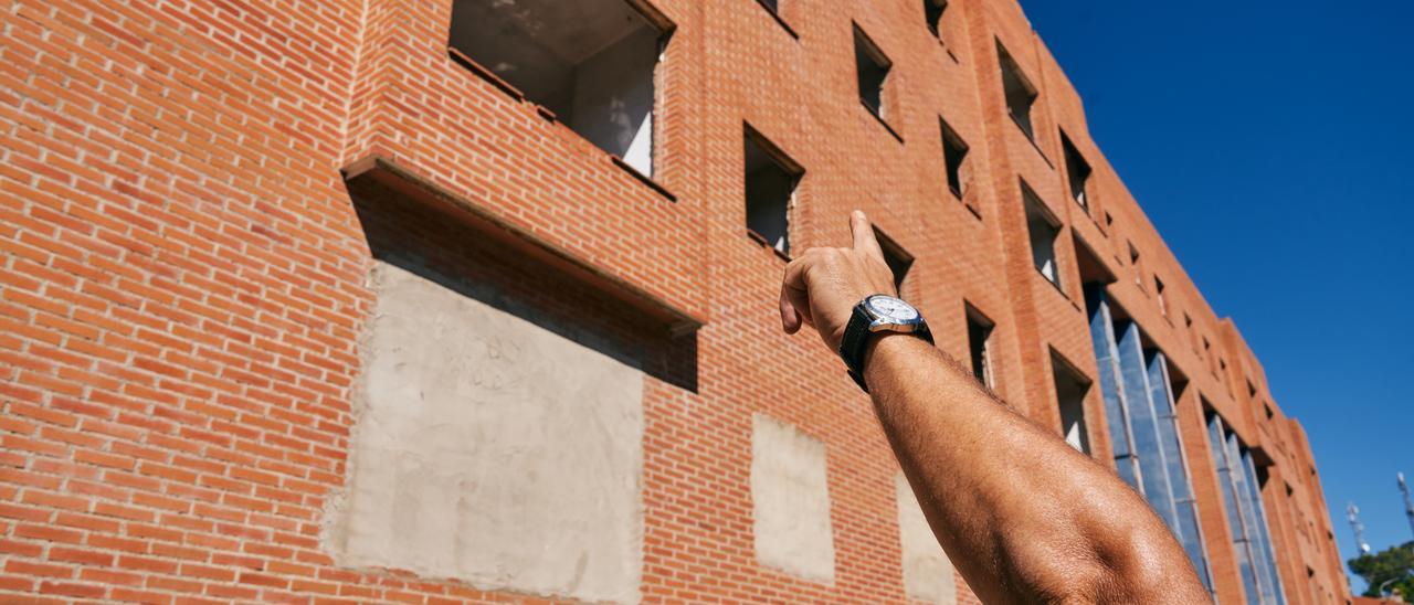 Un vecino del barrio señala el Bloque C, edificio que se derribará tras doce años tapiado.