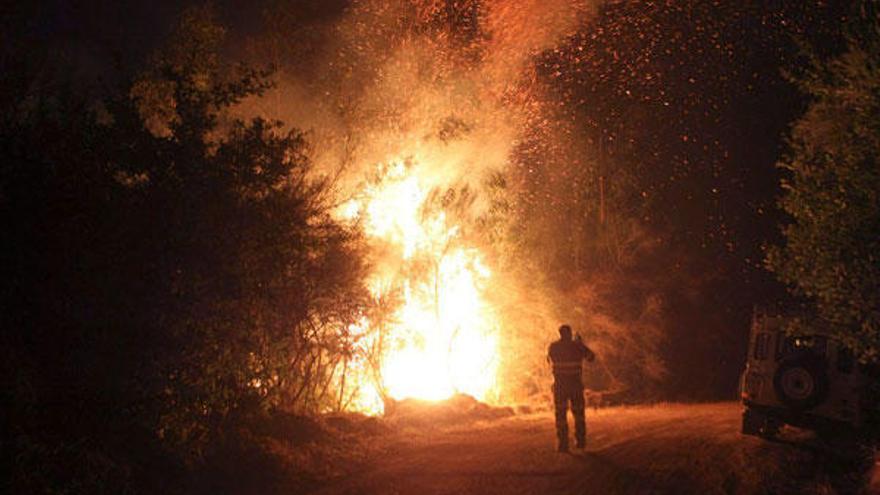 Extinción, anoche, del fuego en Caldas. / EFE / Sxenick