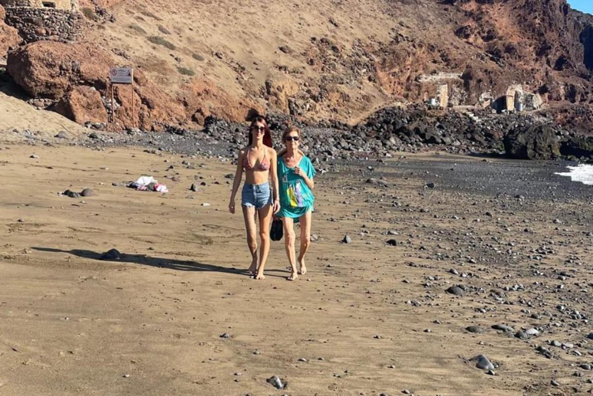 Josefina Gopar con su nieta, paseando por la playa.