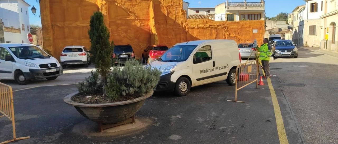 Un operario tomando las mediciones topográficas y una reproducción de cómo quedará la plaza una vez reformada.