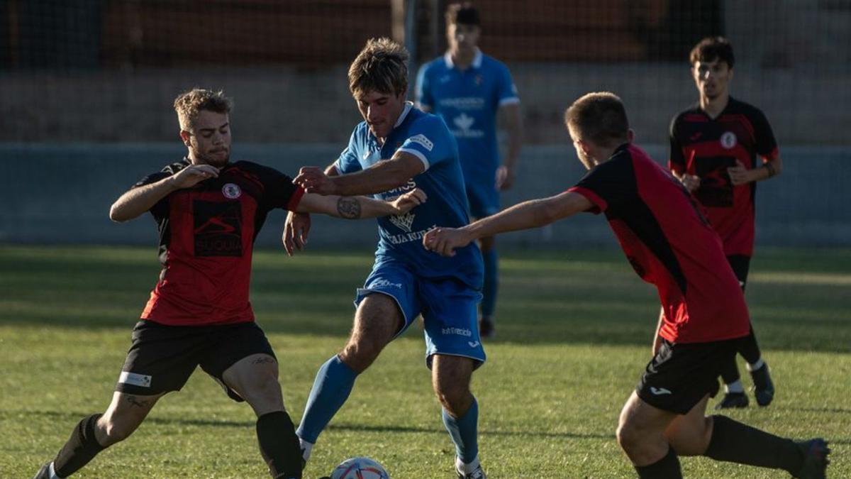 Álvaro de la Iglesia trata de robar el balón a dos adversarios. | Emilio Fraile