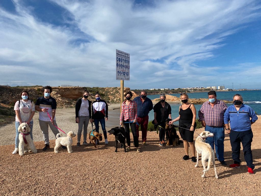 La edil Luisa Boné junto con vecinos con perros en la playa habilitada para el acceso de perros.