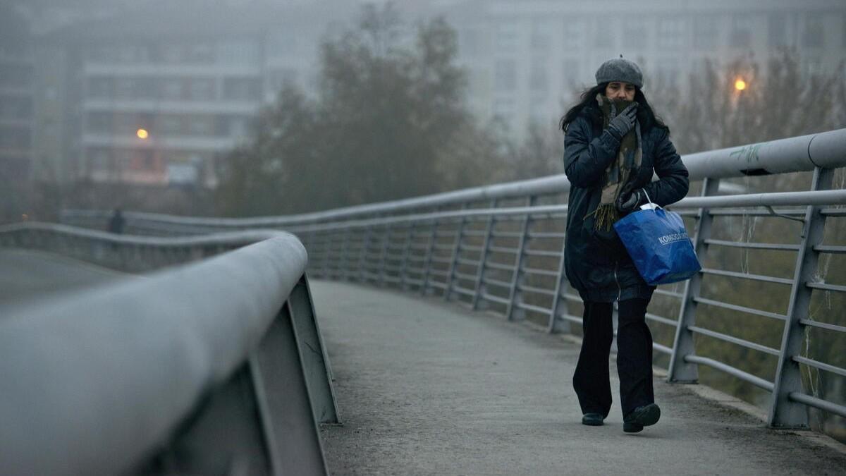 Una mujer se protege del frío en Ourense