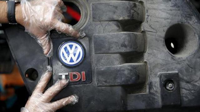 SOBRE EL MOTOR Un operario coloca la tapa de un motor diésel VW .
