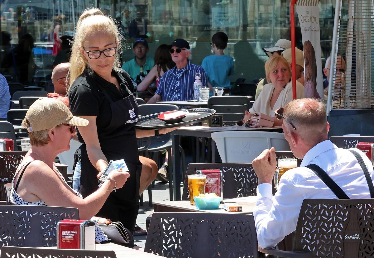 Clientes pagan con tarjeta en la terraza de un local de hostelería de Vigo.