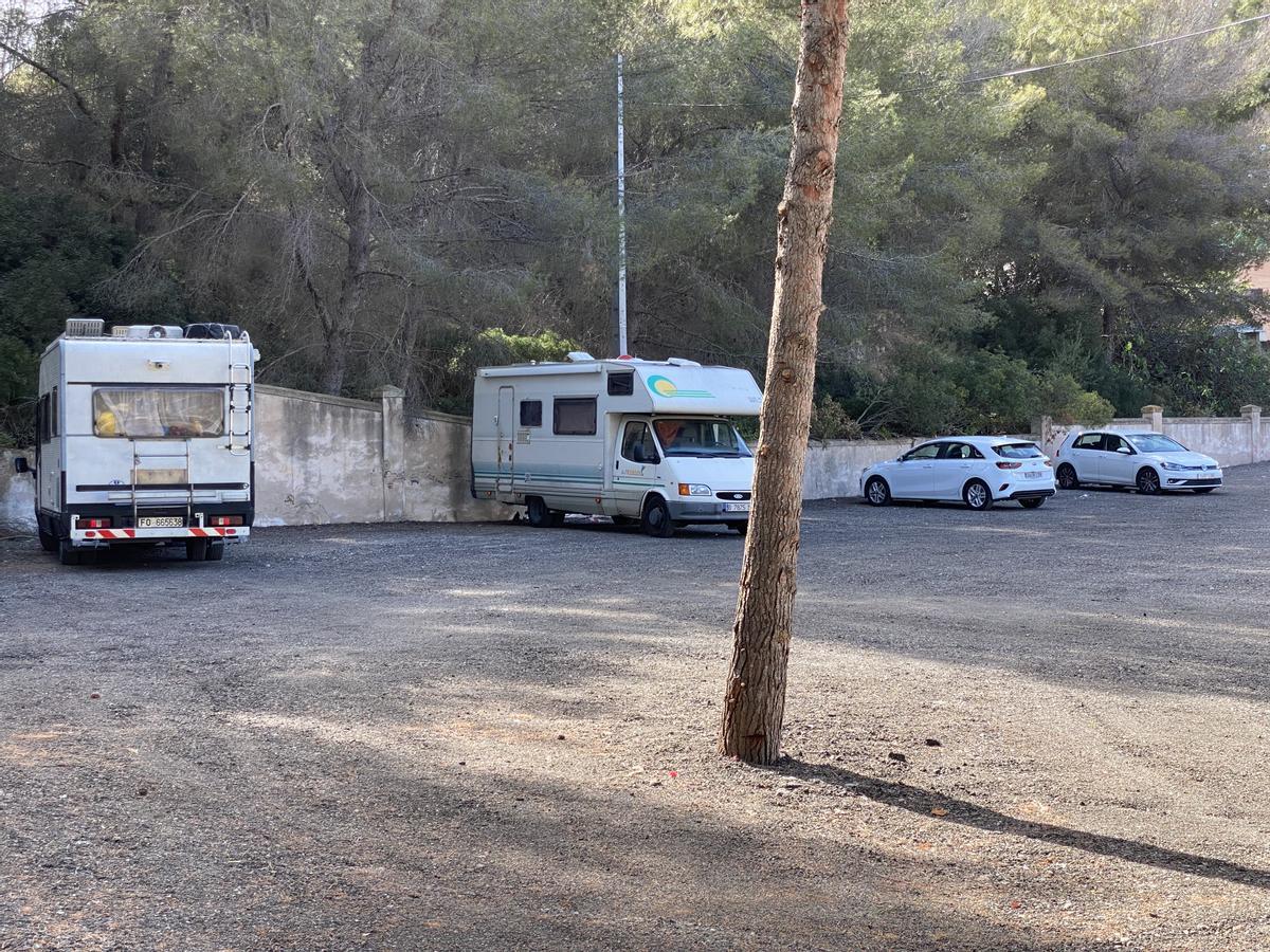 Dos caravanas y dos coches aparcados en la explanada situada a pie de calle