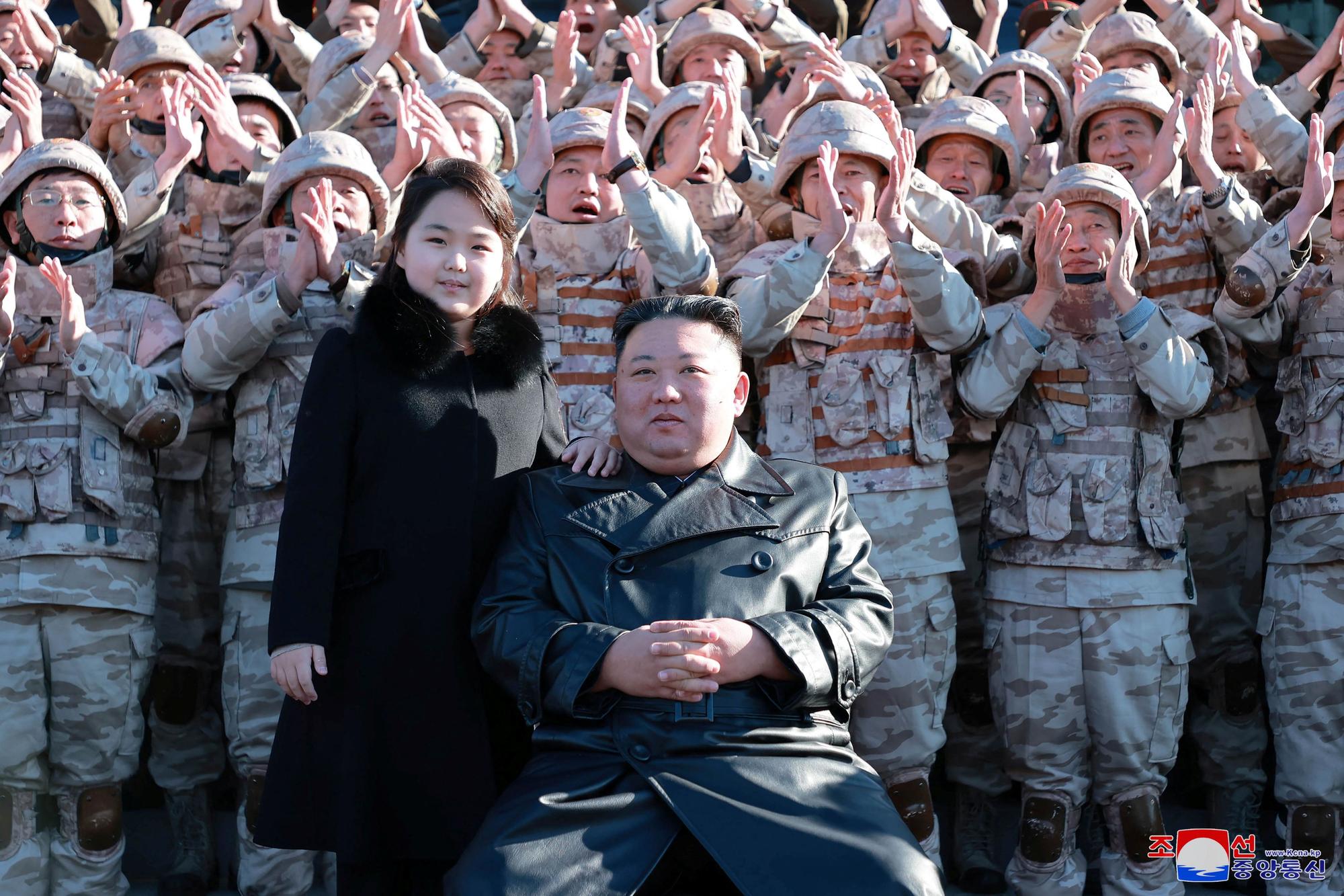 North Korean leader Kim Jong Un and his daughter attend a photo session with personnel involved in the test-fire of the Hwasong-17 intercontinental ballistic missile