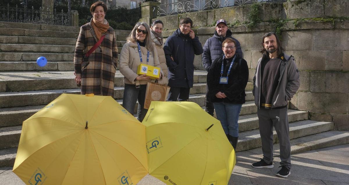 Las guías Rosa Dourado y Natalia Presas, con parte del grupo que aprovechó la ruta gratuita, mostrando sus indicativos profesionales. | ROI CRUZ