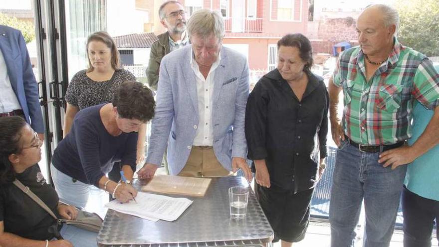 Propietarios de viviendas del edificio Pintos firmando la petición ante Soledad Becerril. // Santos Álvarez