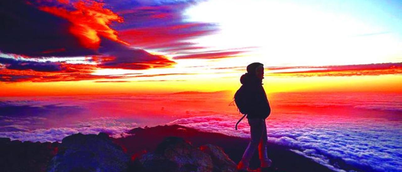 Un senderista en la cima del Teide durante el amanecer.