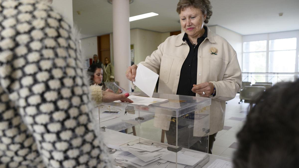 Una persona deposita un voto en las urnas.