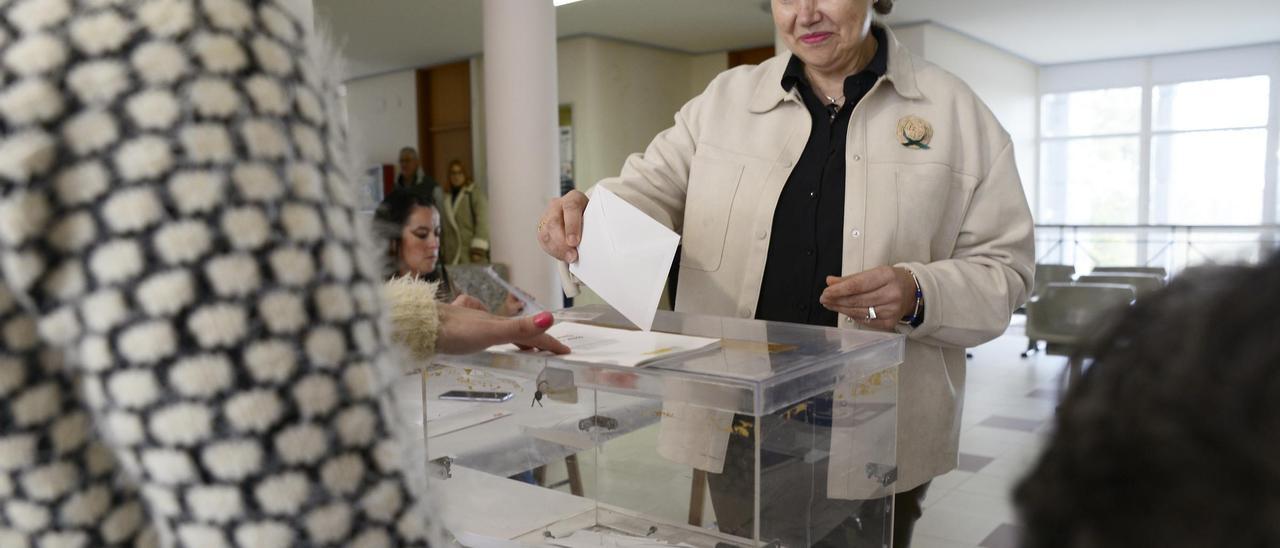 Una persona deposita un voto en las urnas.