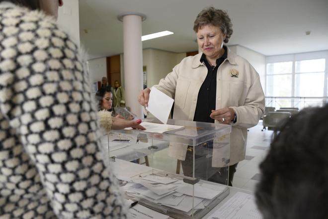 Una persona deposita un voto en las urnas.