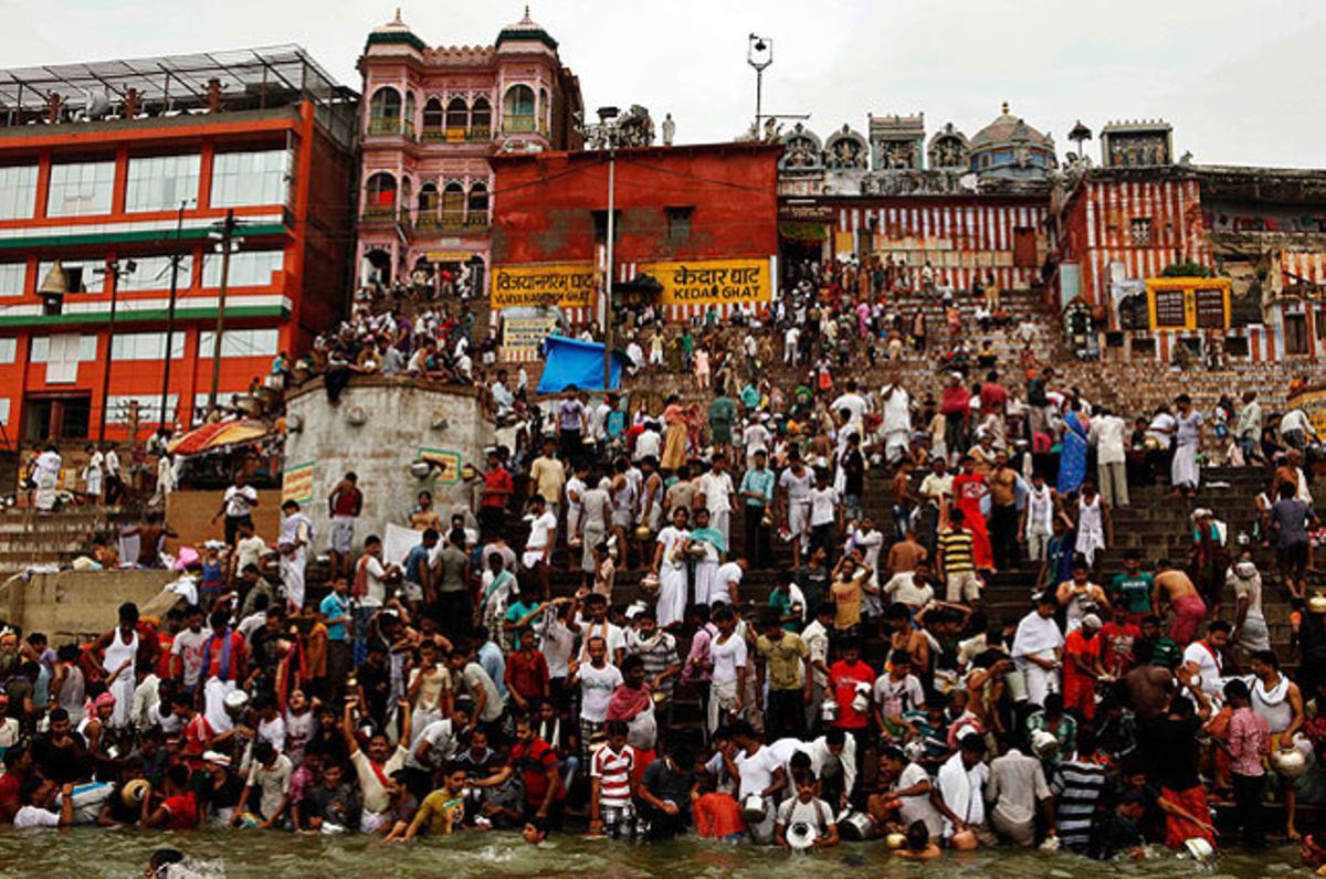 La comunitat pastoral dels Yadavs es banya al Ganges, abans de les pregàries al temple hindú Vishwanath per agrair als déus la pluja, a Varanasi (Índia).