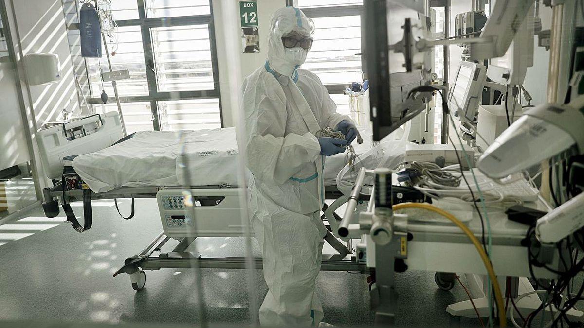 Una sanitaria preparando los boxes de la unidad de cuidados intensivos.