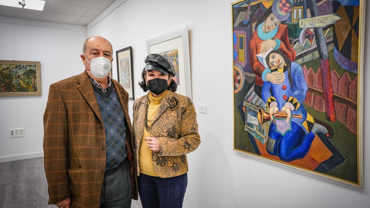 Fernando Saavedra y su mujer Marisol, hija del artista, junto a uno de los cuadros de Silveira expuestos en Espacio CB Arte.