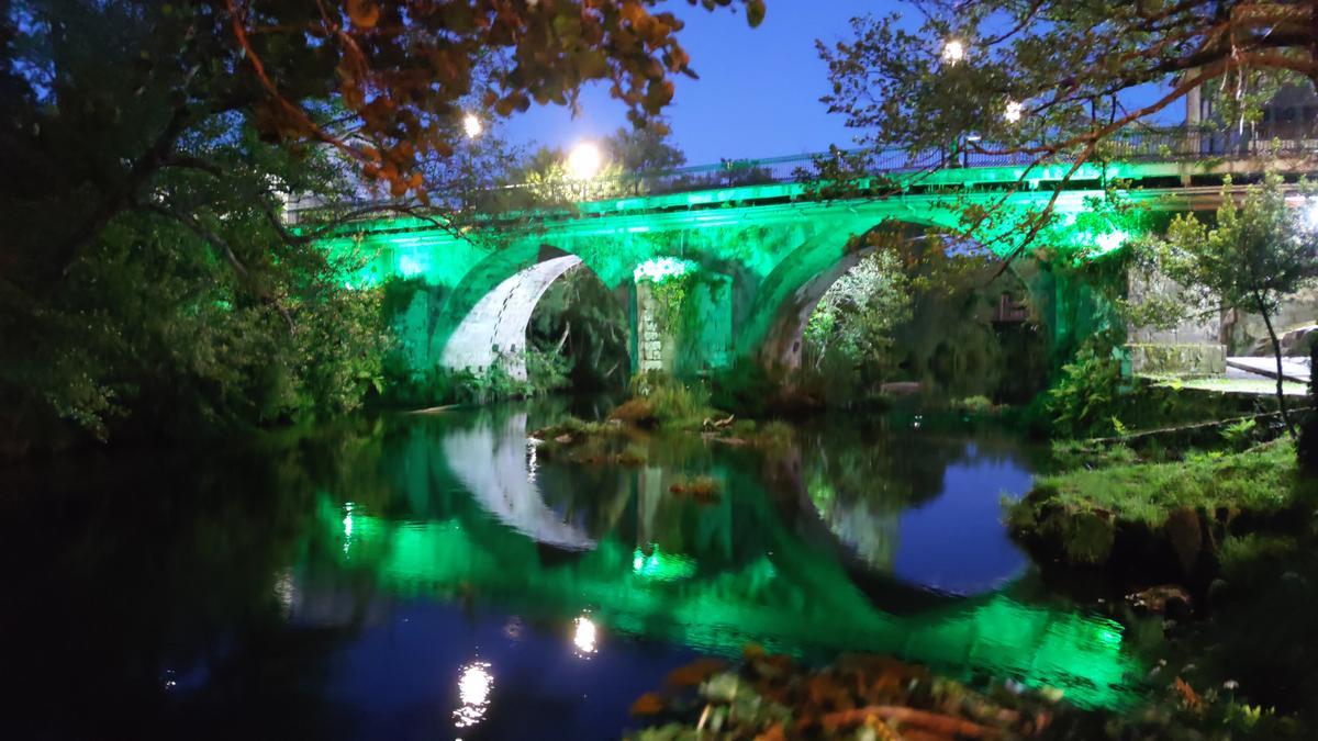 El puente romámico iluminado de verde