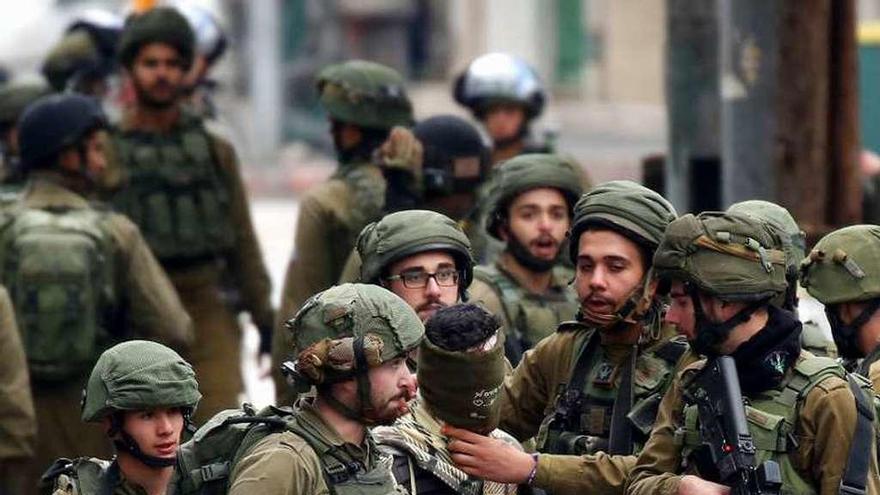 Soldados israelíes detienen a un manifestante palestino en Hebrón.