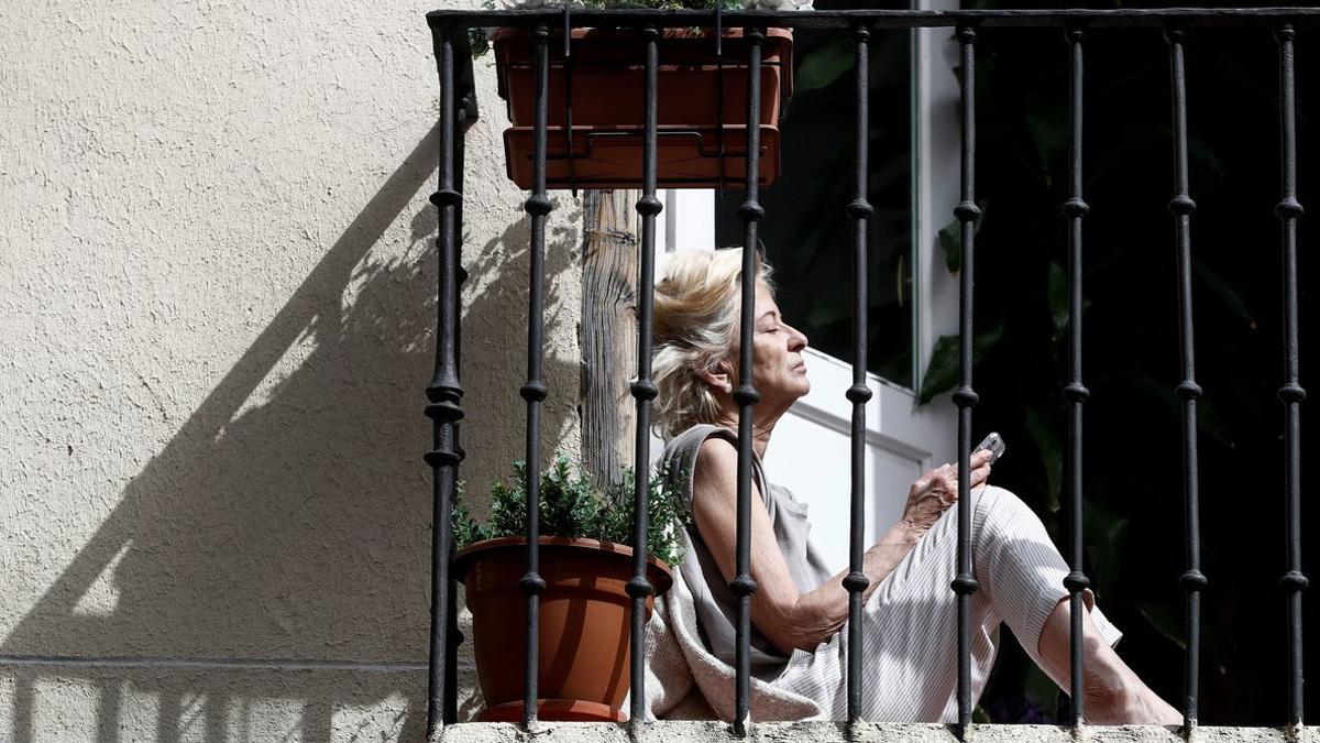 Una señora toma el sol en su balcón, en Madrid, durante el confinamiento.
