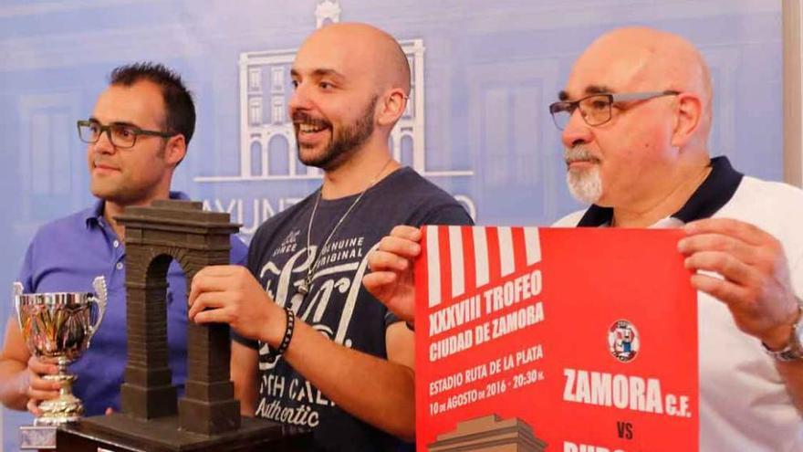 Juanjo Riesco, Manuel A. Alonso y Manuel García posan con los trofeos y el cartel del evento.