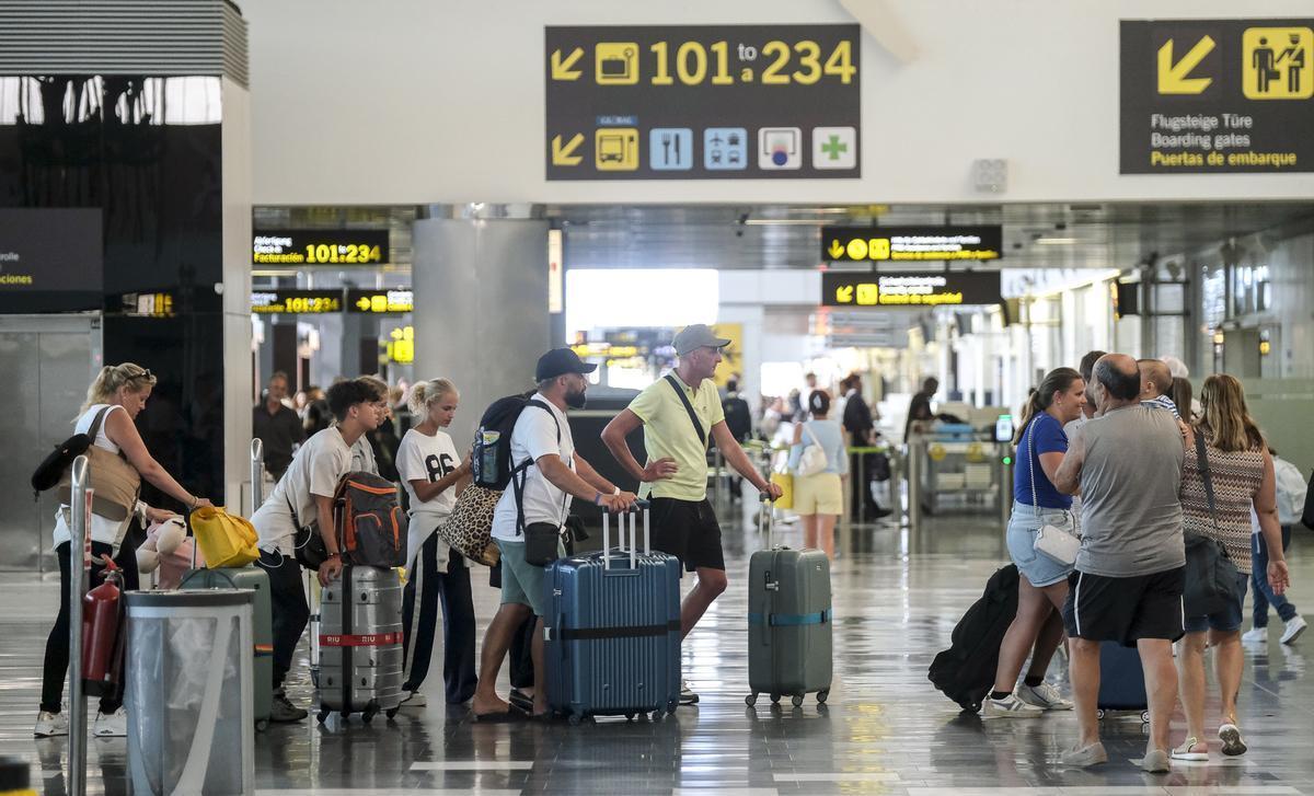 Pasajeros esperando para facturar en un aeropuerto de Canarias.