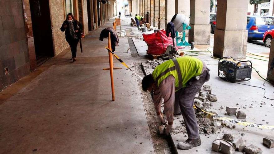 Operarios durante los trabajos de arreglo de la acera.