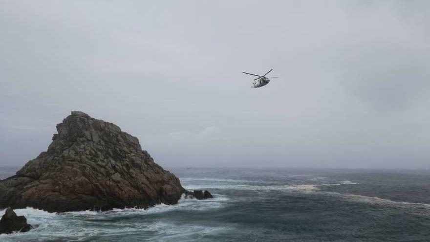 El helicóptero &quot;Pesca I&quot;, ayer durante las labores de búsqueda en Punta Centulo, en Ons.