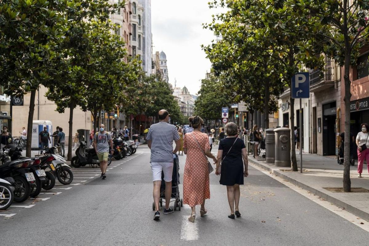 familia-passejant-amb-un-cotxet-pel-c familia-passejant-amb-un-cotxet-pel-c