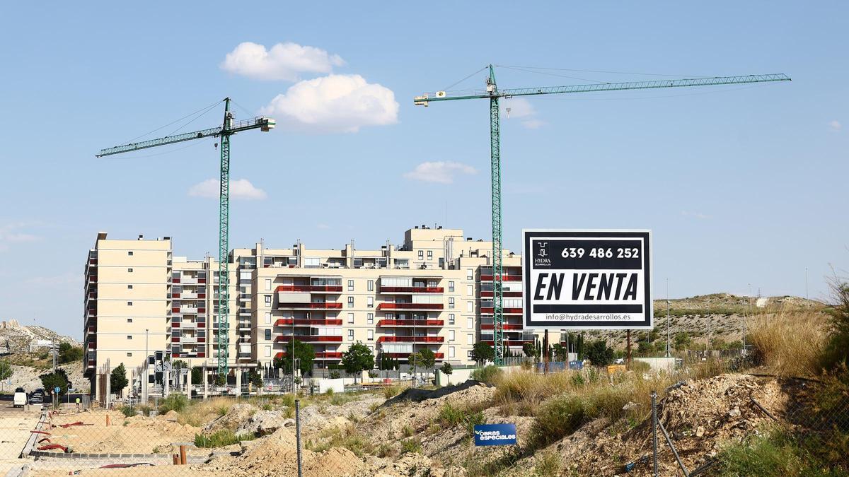 Parcelas para viviendas en venta en Arcosur, con grúas y pisos ya construidos de fondo.