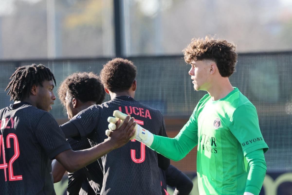 Los jugadores del PSG felicitan a su portero Martin James tras detener el penalti.