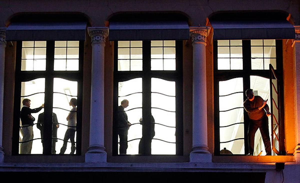 Un home surt a una finestra per fer una foto de les manifestacions d’indignats a Wall Street, Nova York.