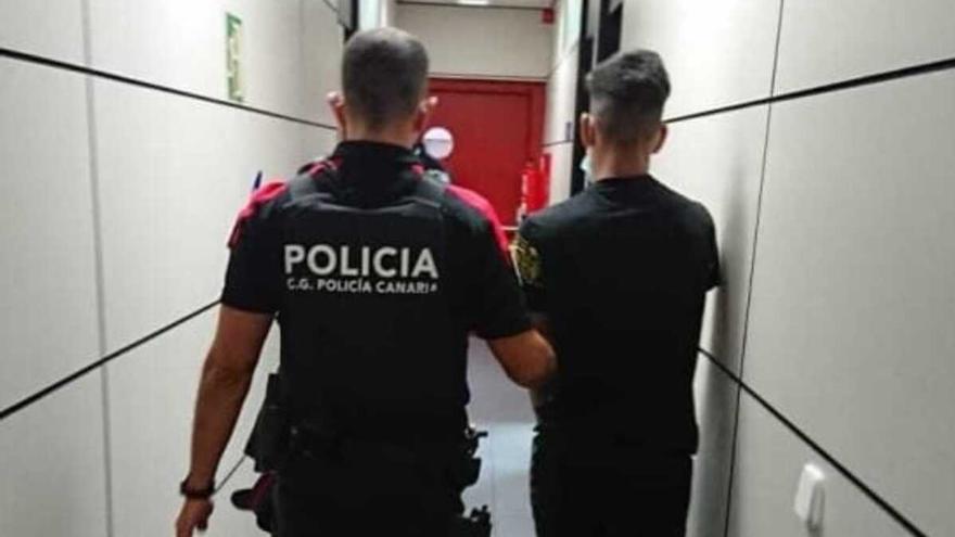 Agente de la Policía Canaria con uno de los presuntos agresores.