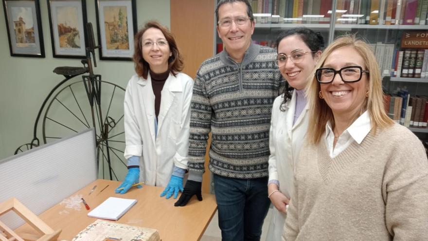 Los investitadores, con el &quot;Aureoum opus&quot;, en el archivo de Alzira.