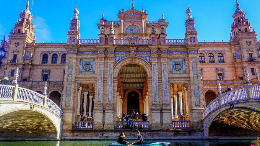 Turistas pasea en barca por la ría de la Plaza de España de Sevilla.