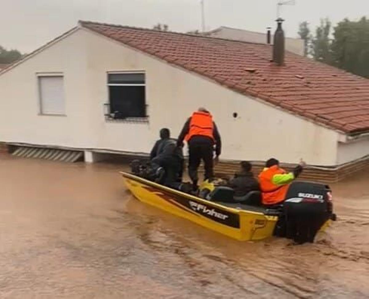 Una barca de pesca rescata a una mujer del segundo piso de su casa en Utiel (València). RIADA HISTÓRICA . DANA 2024 . INUNDACIONES EN LA RIBERA . HORTA SUD Y LA COMARCA DE REQUENA - UTIEL . LLUVIAS . GOTA FRIA