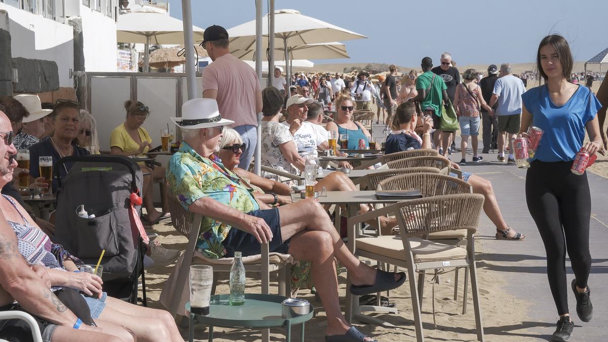 Turistas y visitantes disfrutan del clima de la isla en las terrazas de los establecimientos del centro comercial Oasis, en Maspalomas.