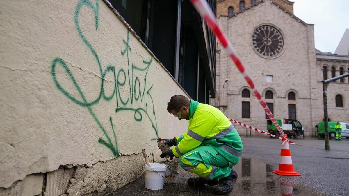 Un operario de Cuidem Barcelona realizando tareas de limpieza de pintadas en la Plaza de Terenci Moix