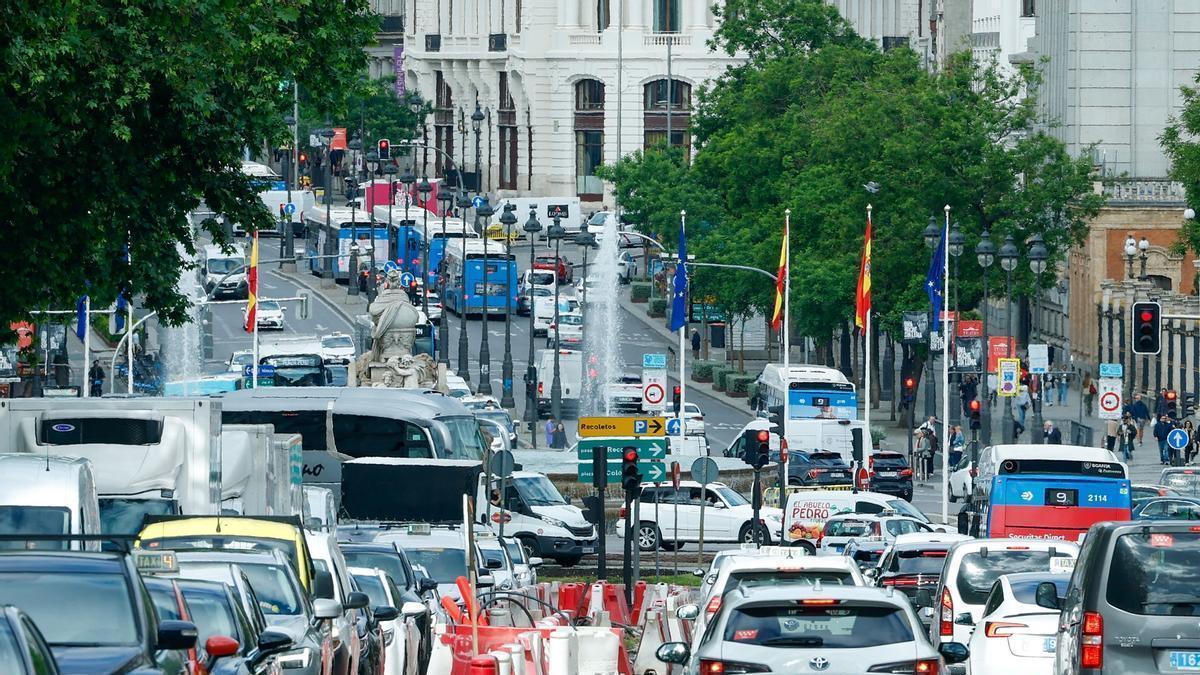 Coches y autobuses, circulando por una de las calles de Madrid.