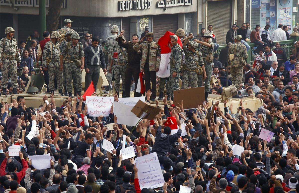 Un oficial del Ejército egipcio saluda a los manifestantes desde lo alto de un vehículo militar en la plaza de Tahrir, en El Cairo, el 29 de enero del 2011.