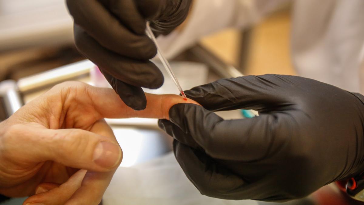 Una enfermera toma una muestra de sangre a un aragonés para realizarle una prueba rápida de vih.