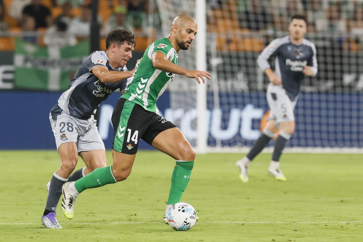 SEVILLA, 19/09/2025.- El centrocampista del Betis Sofyan Amrabat (d) se escapa de Pablo MarÃ­n, de la Real Sociedad, durante el partido de la jornada 5 de LaLiga EA Sports entre el Real Betis y la Real Sociedad, este viernes en el estadio de La Cartuja, en Sevilla. EFE/ JosÃ© Manuel Vidal