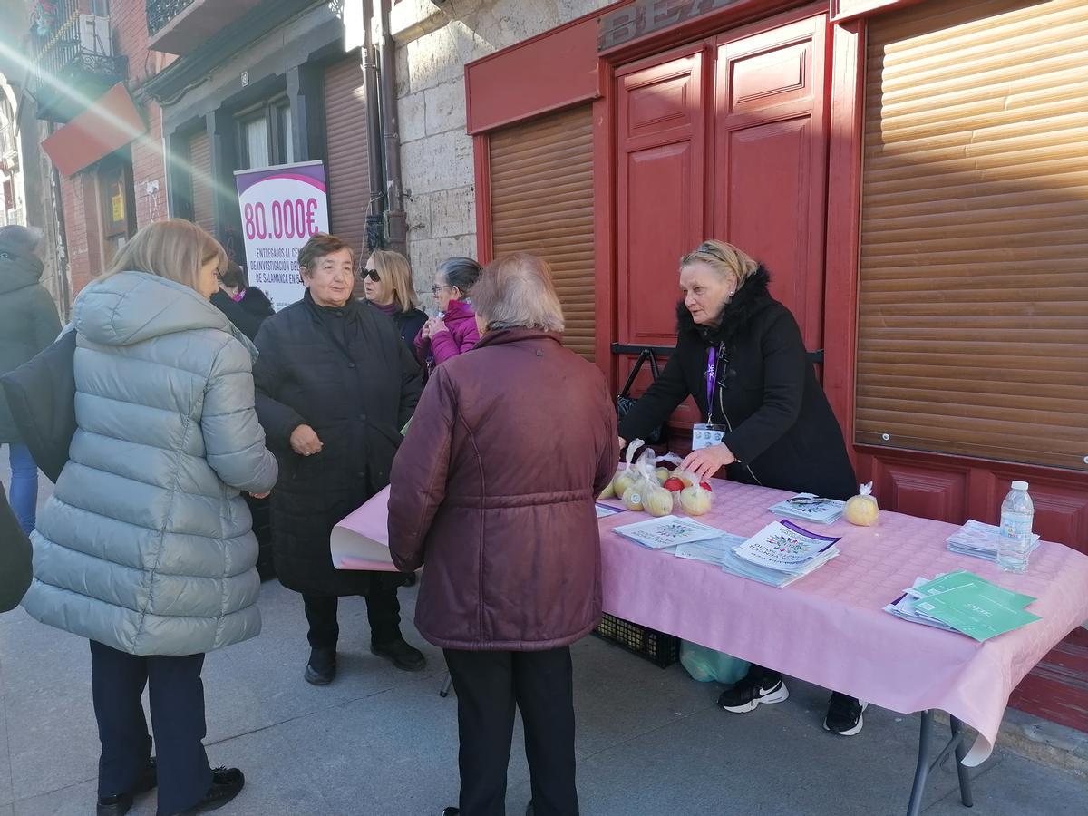 Voluntarias de la asociación reparten manzanas entre los vecinos