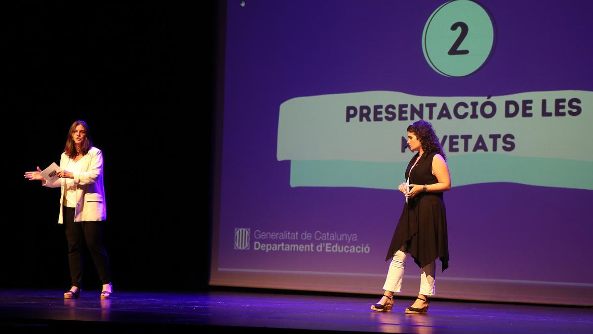 Las directoras generales de Atenció a la Família i Comunitat Educativa y de Alumnado microfonadas presentando el programa antes decenas de direcciones en el teatro Zorrilla la semana pasada.
