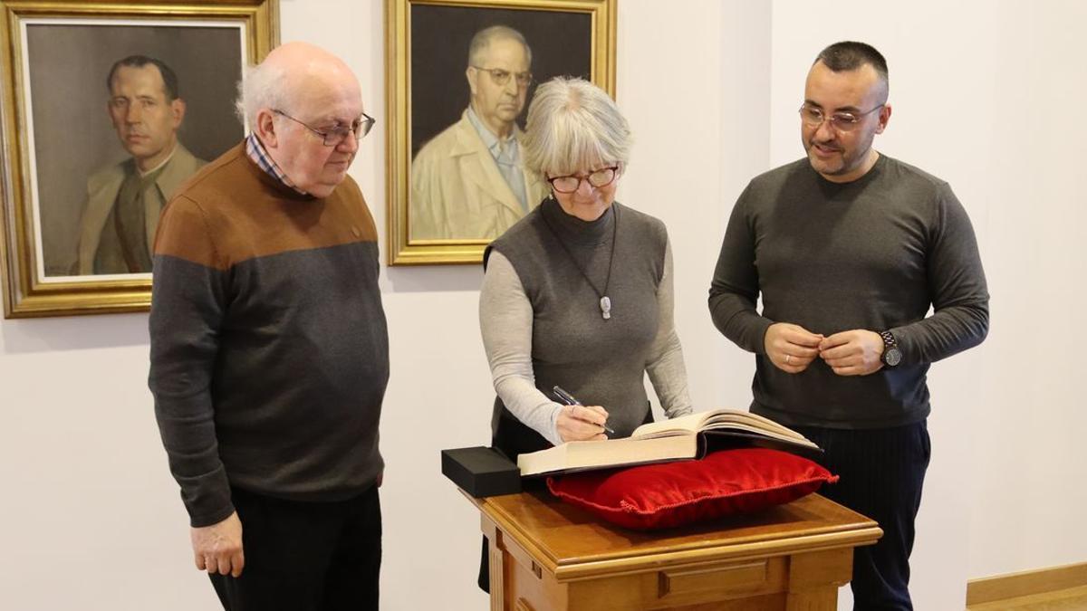 Yasmina Bernat Ortells signa en el llibre d’honors de la ciutat en presència de l’alcalde Benlloch i del professor Heredia.