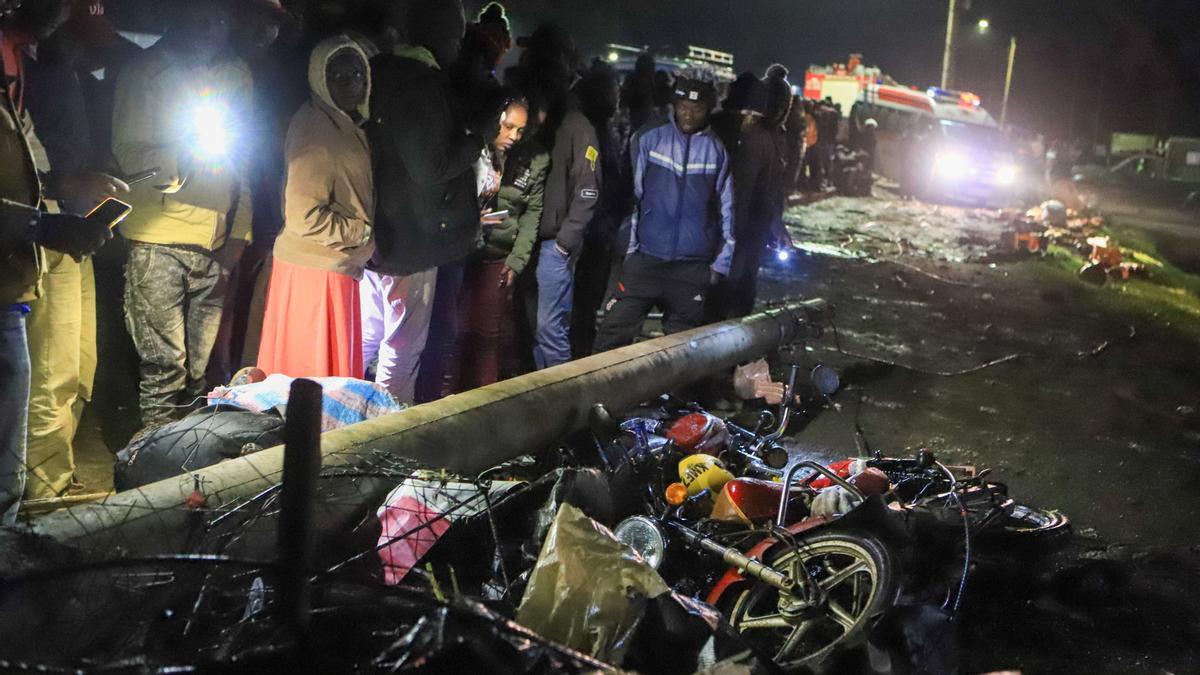 Un grupo de personas observan el lugar del accidente entre un camión y varios vehículos, este sábado en Kenia.