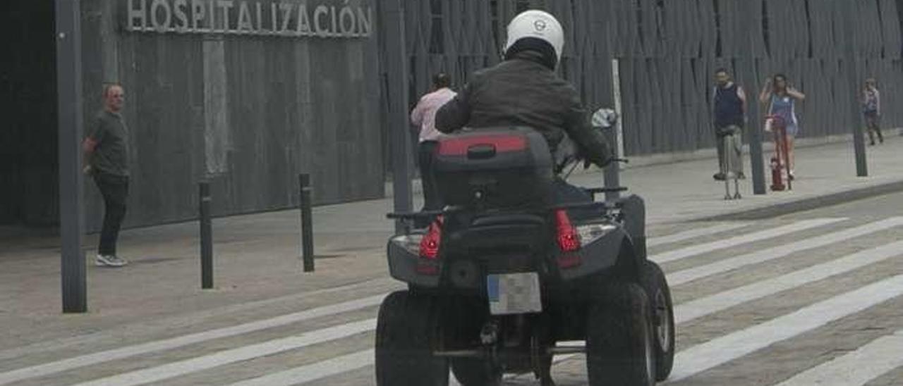 Un quad, pasando por la calle ante el HUCA.